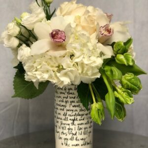 Photo of parrot tulips, white cymbidium orchids, white hydrangeas, roses and lisianthus in a vase with writing